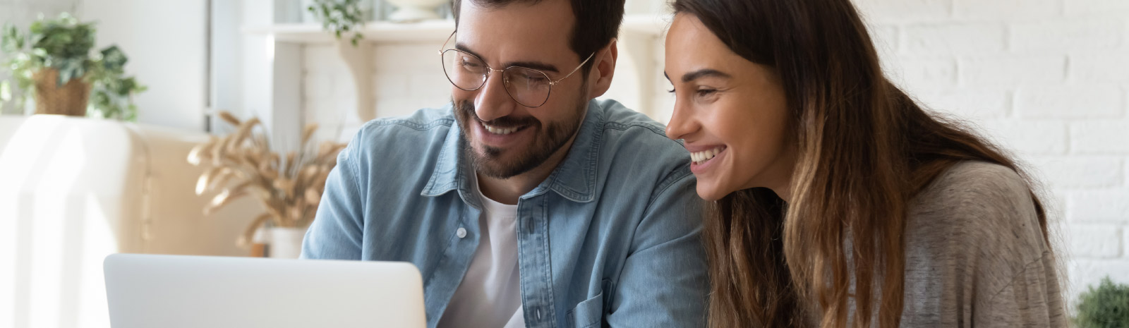 a man and woman looking at a laptop computer.