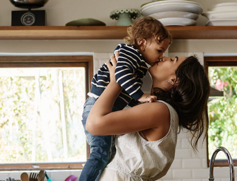 a mother kissing her child